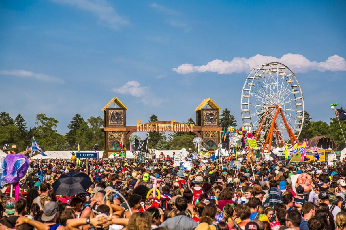 Image of the crowd at electric forest during the day with the ferris wheel in the back