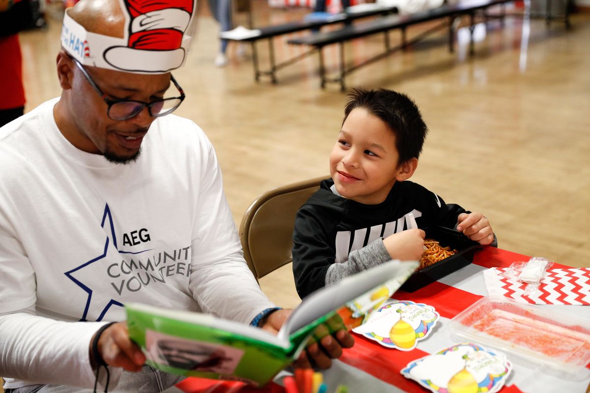 An AEG employee volunteer reads to a student at 10th Street Elementary during AEG's Read Across America Day Celebration.