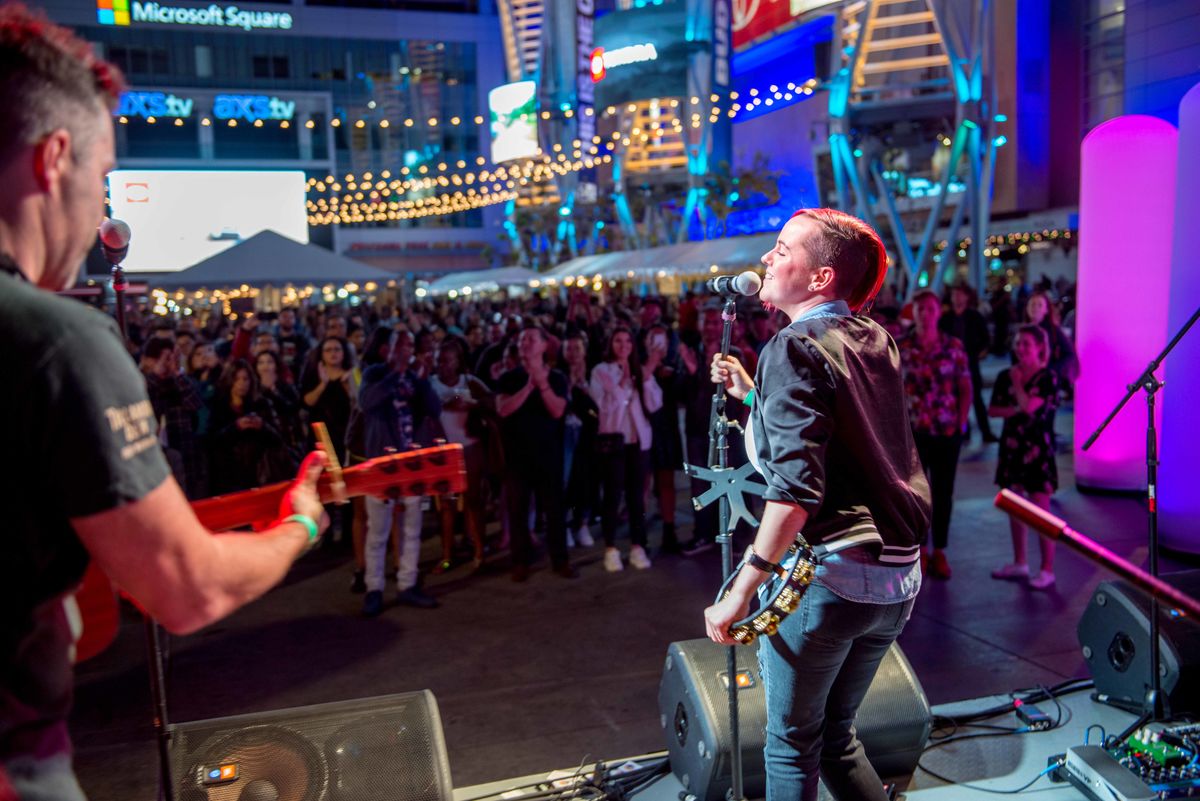 A singer in a live band at L.A. LIVE's Block Party event performs to a crowd in Microsoft Square. 