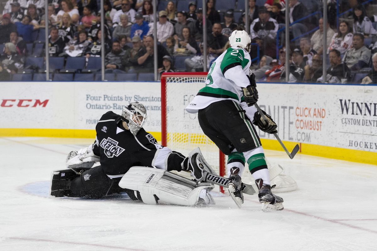 Reign goalie blocking a shot from opposing player